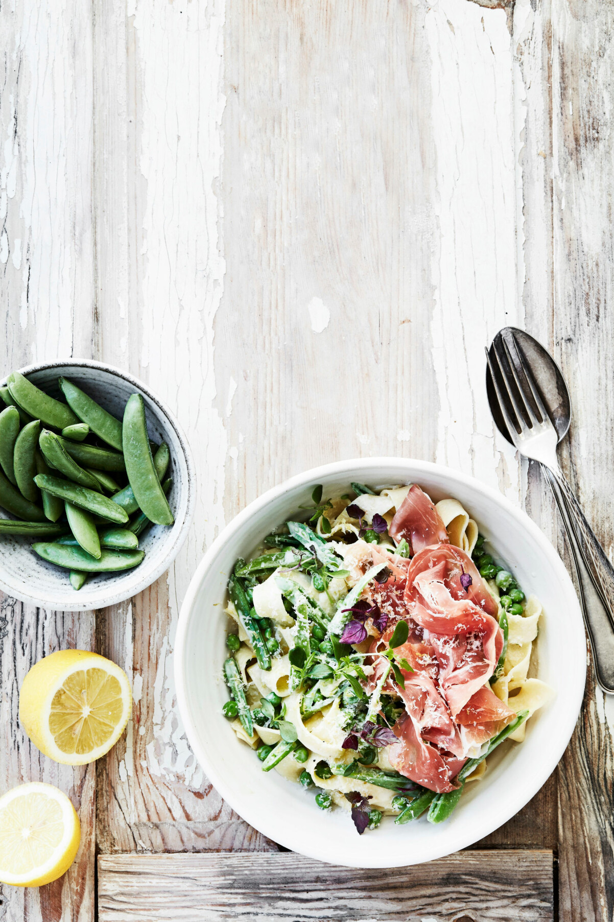 Skal och saft från citron tar den här pastarätten till nya höjder. Pappardelle med gräddiga ärter och lufttorkad skinka