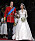 Prins William och Kate Middleton på sin bröllopsdag, strax efter vigseln. Kate bär vit bröllopsklänning med långa spetsärmar och vid kjol samt slöja som sitter fast på huvudet med hjälp av ett diadem. I handen håller hon en bukett med vita blommor.
