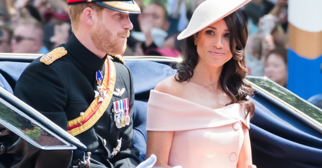 De här klänningen ansåg många vara för vulgär när Meghan gjorde debut på Buckingham Palace. Meghan Markle i ljusrosa klänning med bara axlar. På huvudet har hon en hatt i samma rosa nyans.