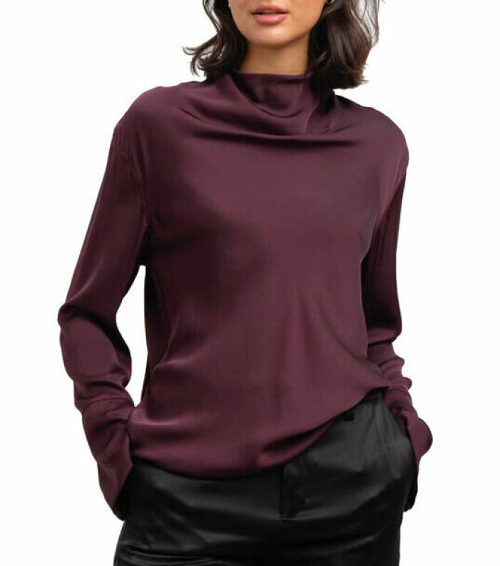 Topp, Ahlvar Gallery. <a target="_blank" rel="nofollow" href="https://in.ahlens.se/t/t?a=1136856392&as=1218462148&t=2&tk=1&epi=an-tvprofilerna&url=https://www.ahlens.se/Mode/overdelar-592164/ahlvar-gallery-ayumi-blouse-burgundy-65326130/">Klicka på bilden för att komma direkt till produkten!</a> Modell med vinröd topp i siden. Toppen har långa ärmar och draperad uppe vid halsen. Sidentopp från Ahlvar gallery.