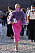 Street style bild på kvinna i lila blus med volanger i plisserad struktur, Till det bär hon en cerise pennkjol och clutch och sandaletter i silver. Bild tagen utanför Alberta Ferrettis ss21 visning.