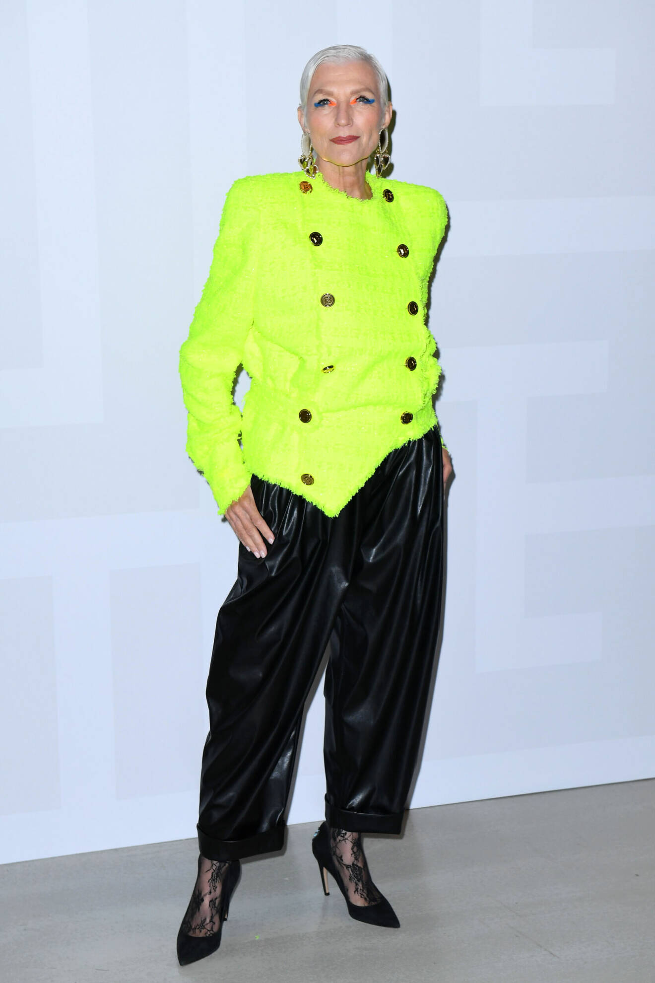 Maye Musk iklädd färgstark jacka och svarta skinnbyxor.