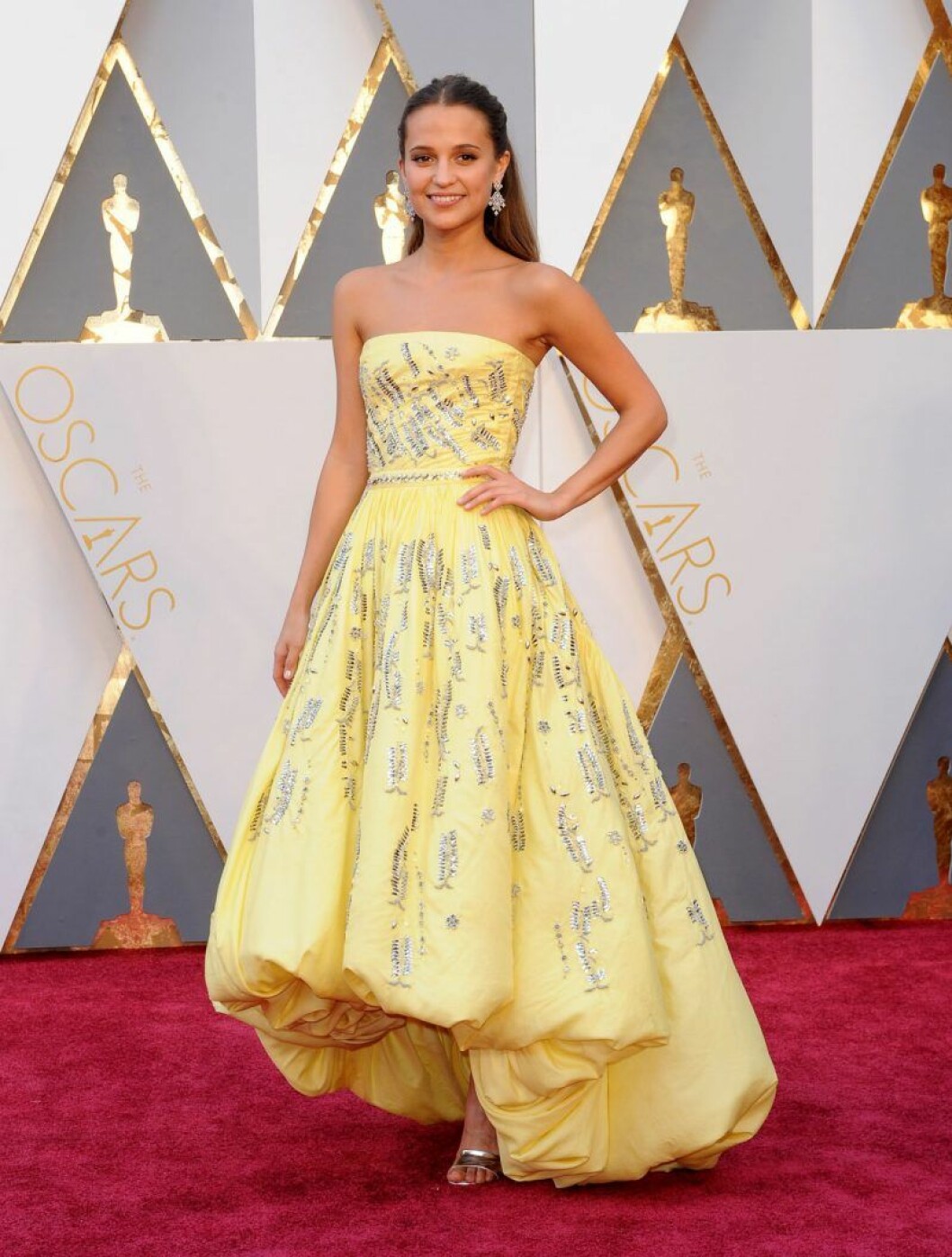 Alicia Vikander på Oscarsgalan 2016 – samma år som som hon vann pris i kategorin bästa kvinnliga biroll. Alicia Vikander i en gul klänning
