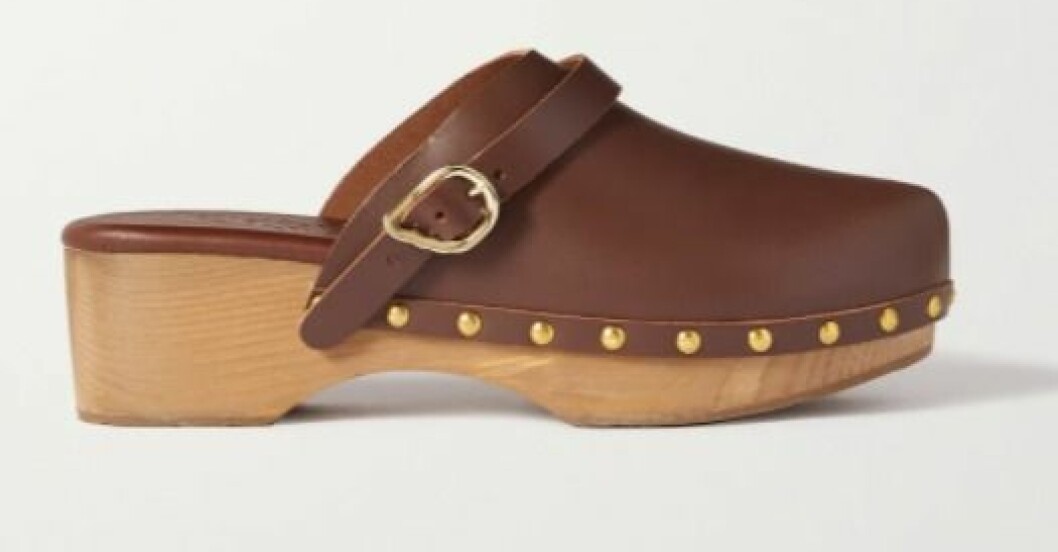 Träskor, Ancient Greek Sandals. <a target="_blank" rel="nofollow" href="https://apprl.com/al/6sqZ/">Klicka på bilden för att komma direkt till produkten!</a> Träskor i brunt skinn med spänne och runda, guldfärgade nitar. Träsula. Träskor från Ancient Greek Sandals.