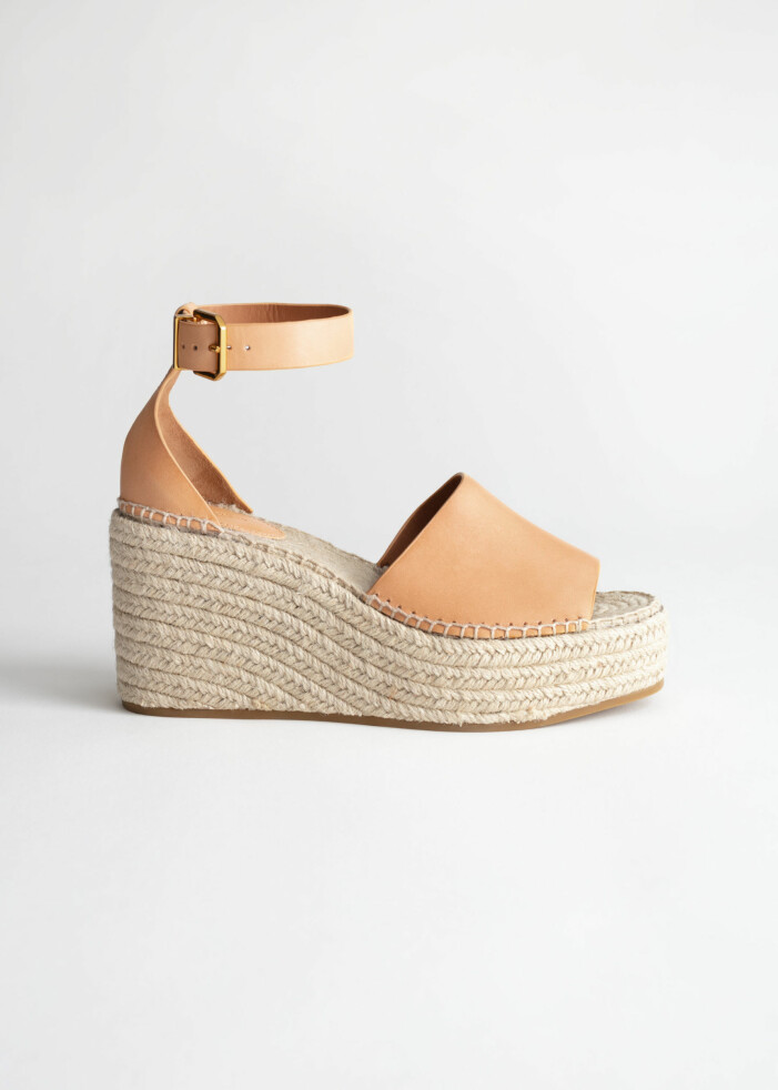 Espadrillos, And other stories. <a target="_blank" rel="nofollow" href="https://track.adtraction.com/t/t?a=1279077969&as=1218462148&t=2&tk=1&epi=an-5skor&url=https://www.stories.com/en_sek/shoes/heeled-sandals/product.espadrille-sandal-wedges-orange.0746756001.html">Klicka på bilden för att komma direkt till produkten!</a> Espadrillos med vävd kilklack och ljusbruna remmar över fot och runt vrist. Skor från And other stories.