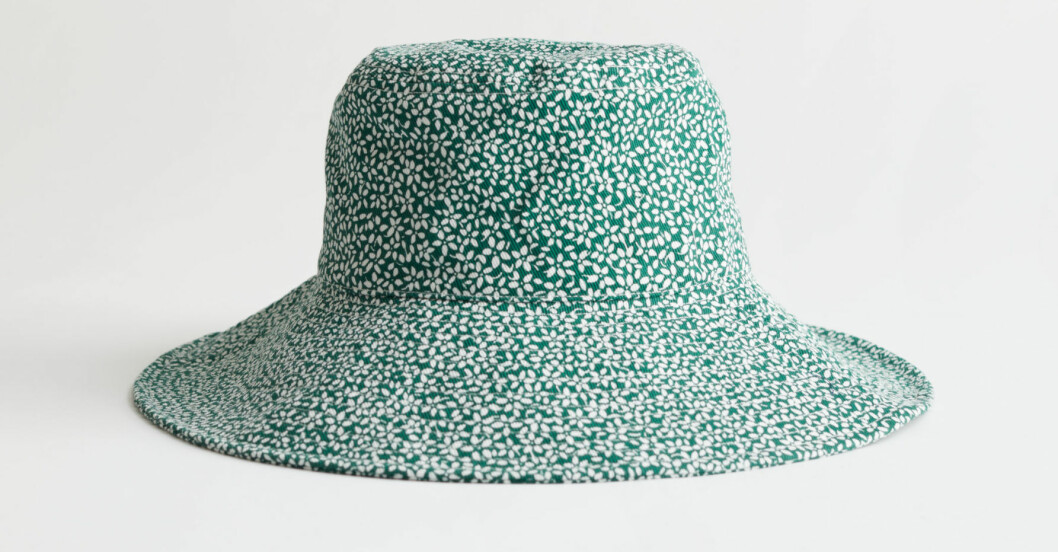 Hatt, And other stories. <a target="_blank" rel="nofollow" href="https://track.adtraction.com/t/t?a=1279077969&as=1218462148&t=2&tk=1&epi=an-beppehatt&url=https://www.stories.com/en_sek/accessories/headwear/bucket-hats/product.floral-printed-bucket-hat-green.0959527001.html">Klicka på bilden för att komma direkt till produkten!</a> Vitblommig Beppe-hatt med grön bakgrund. Bucket hat från And other stories.