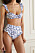 Vit bikini med blått blommönster. Volanger på axelbanden och på trosorna med hög midja. Bikini från Agua by Agua Bendita.