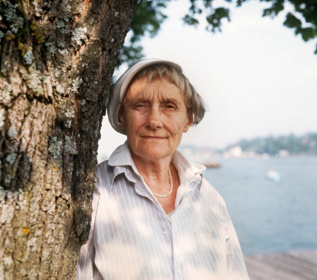 Astrid Lindgren 1987. Bild: Ibl Bildbyrå Astrid Lindgren tittar fram bakom ett träd 1987.