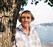 Astrid Lindgren tittar fram bakom ett träd 1987.