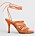Orange sandalett med hög klack och flera tunna, flätade remmar över foten och långa remmar som ska knytas runt vristen. Sandaletter från Atp Atelier.