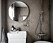 Stor rund spegel i snyggt litet badrum
