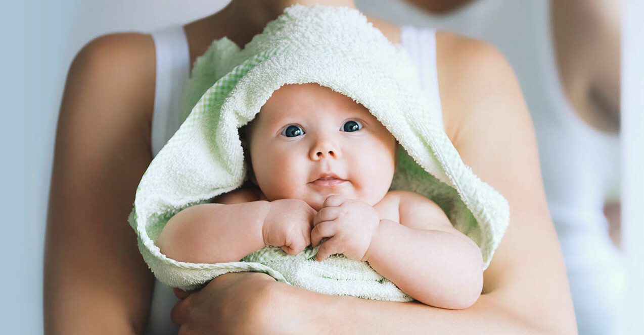 en bebis i grön badhandduk