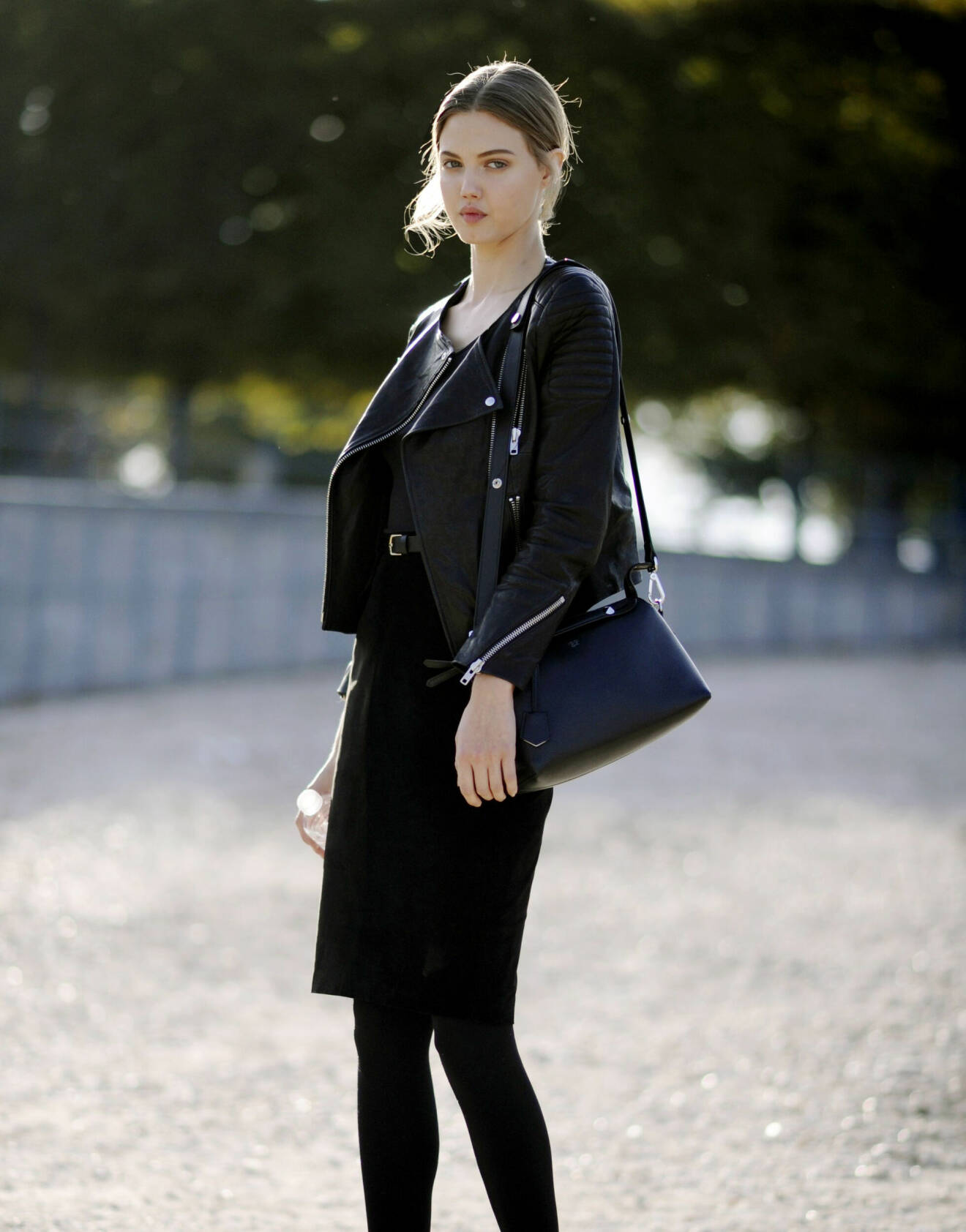 Supermodellen Lindsey Wixson bär svart bikerjacka tillsammans med pennkjol.