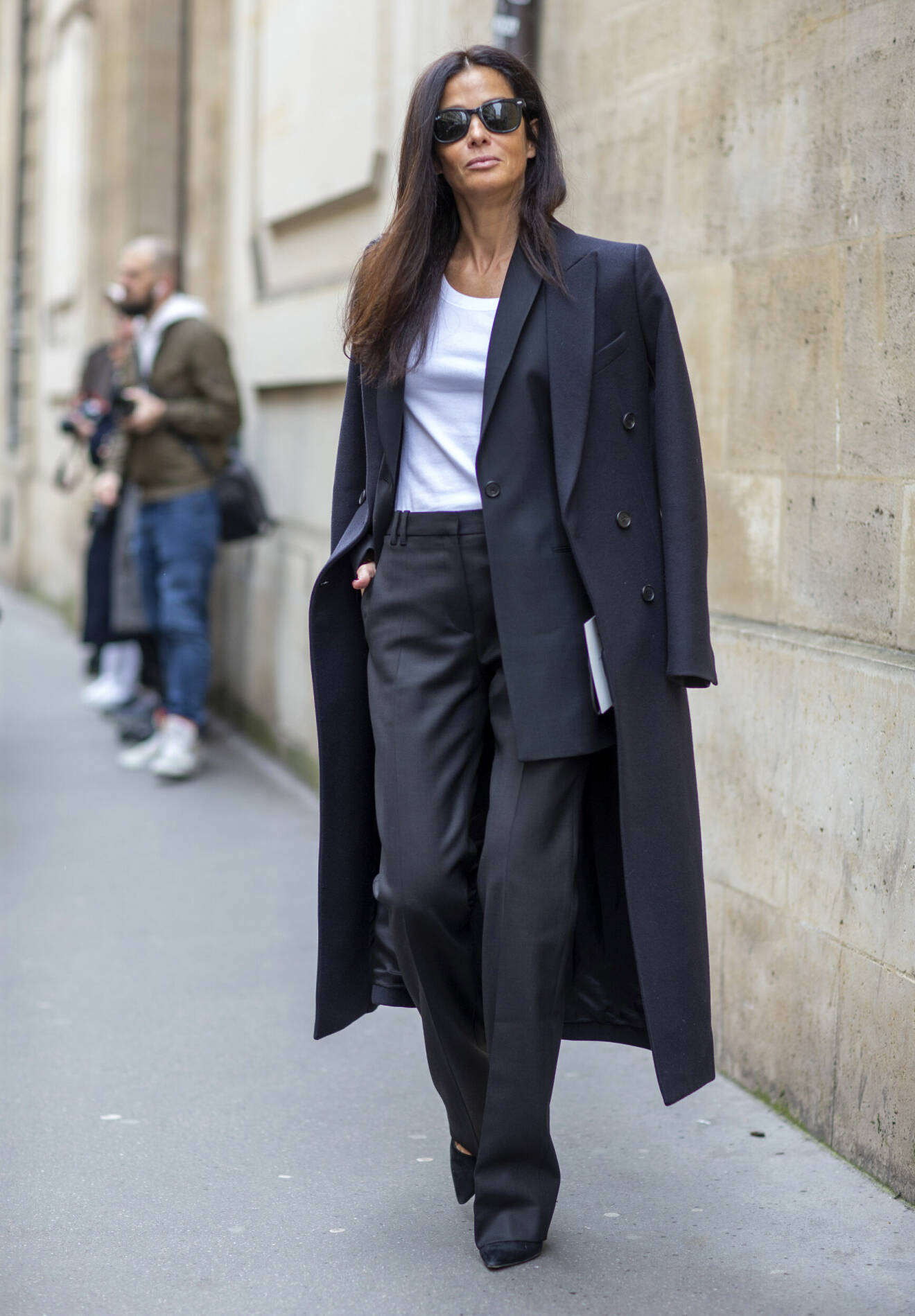 Svarta byxor bärs tillsammans med matchande kavaj i en klassisk look.