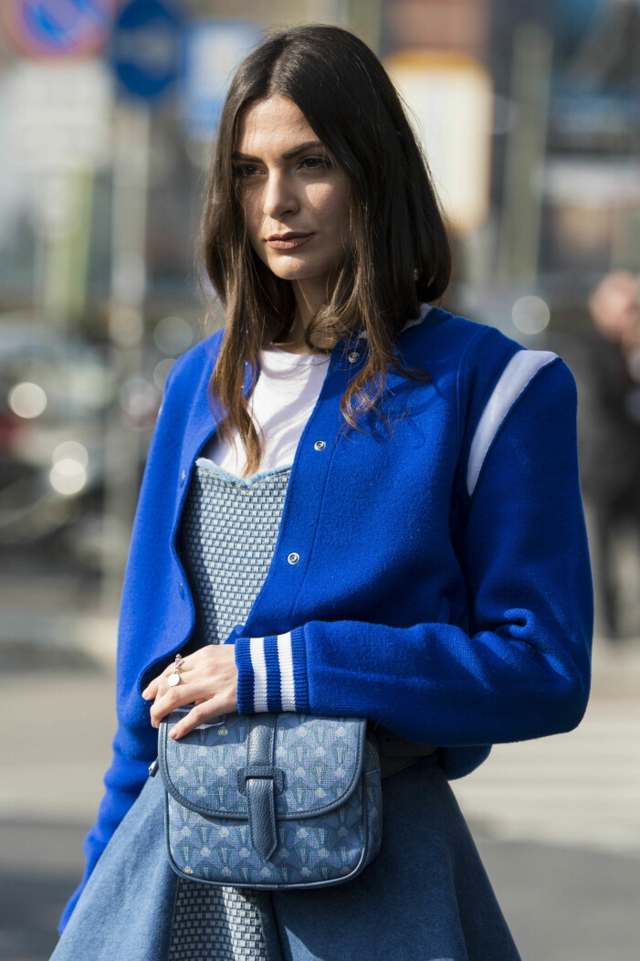 Less is more när det kommer till hår och makeup. Foto: TT. Närbild på kvinna med brunt hår och naturlig makeup och naturliga naglar. Hon har en outfit i olika blå nyanser och vitt.