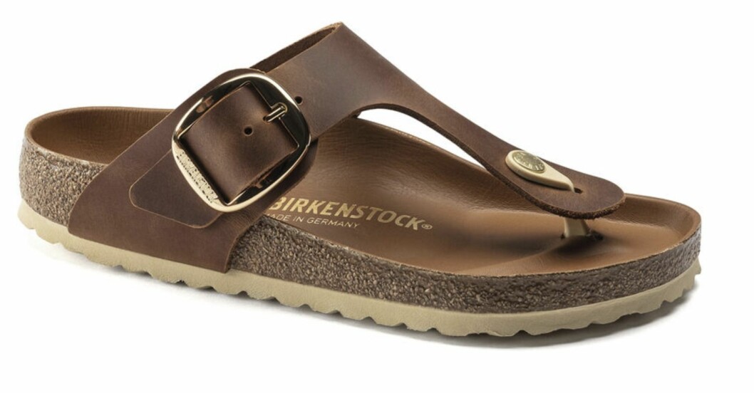 Tofflor, Birkenstock. Bruna tofflor i läder, flip-flop-modell och stor spänne på sidan. Tofflor från Birkenstock.