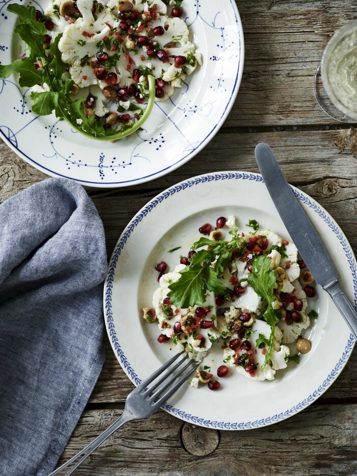 Syrliga granatäpplekärnor, pepprig rucola och mild blomkål ger en god och näringsrik vintersallad. Blomkålssallad med granatäpplevinegrätt.