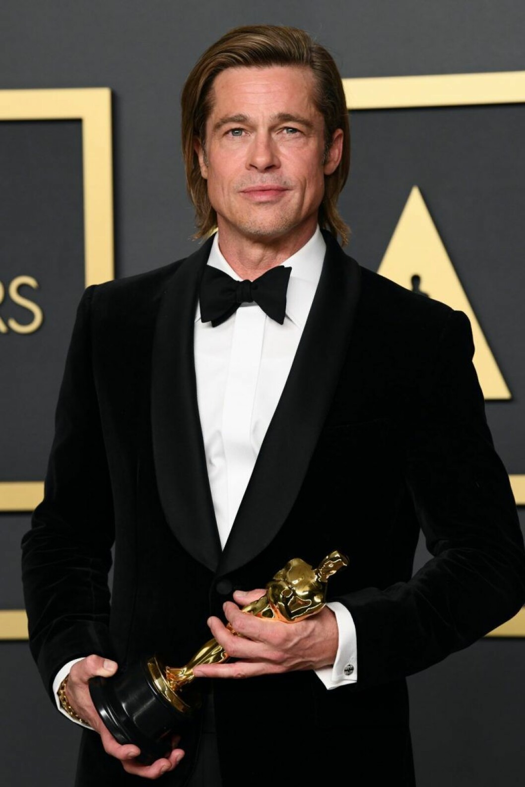 Brad Pitt innan karantän. Brad Pitt I smoking håller i en statyett.