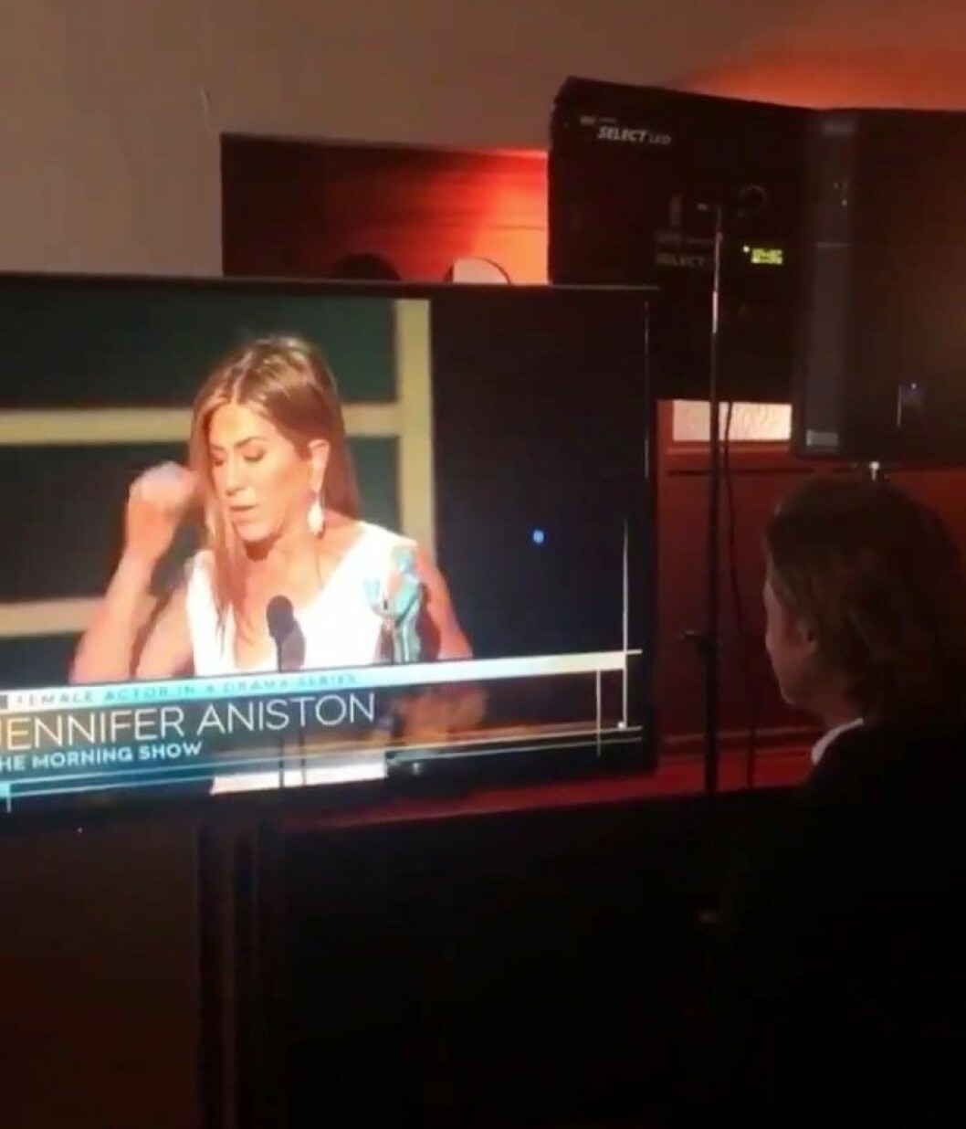 Och när det sedan var Jennifers tur att vinna pris och hålla tal stod Brad bakom scenen och tittade. Brad Pitt tittar på tv när Jennifer Aniston vinner pris