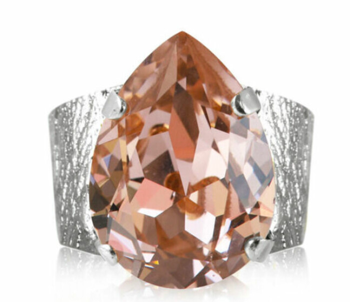 Bred, silverfärgad ring, justerbar. Men stor, rosa Swarovski-kristall. Ring från Caroline Svedbom.