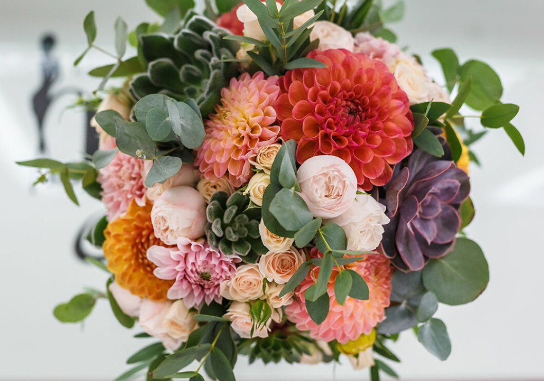 Dahlia i en bukett med eukalyptus och rosor
