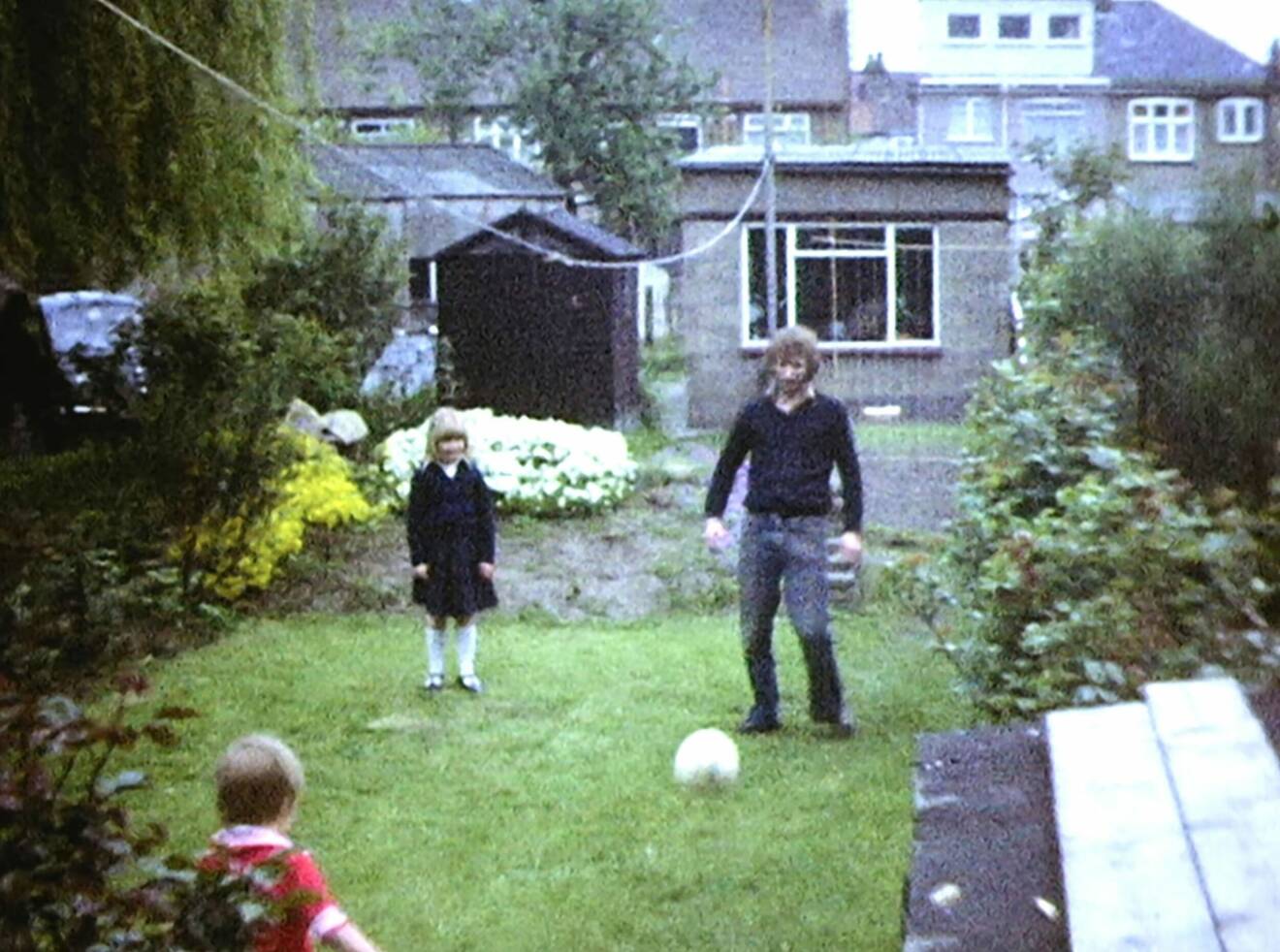 Bild från bandomen på David Beckham som spelar fotboll med sin pappa hemma i trädgården.