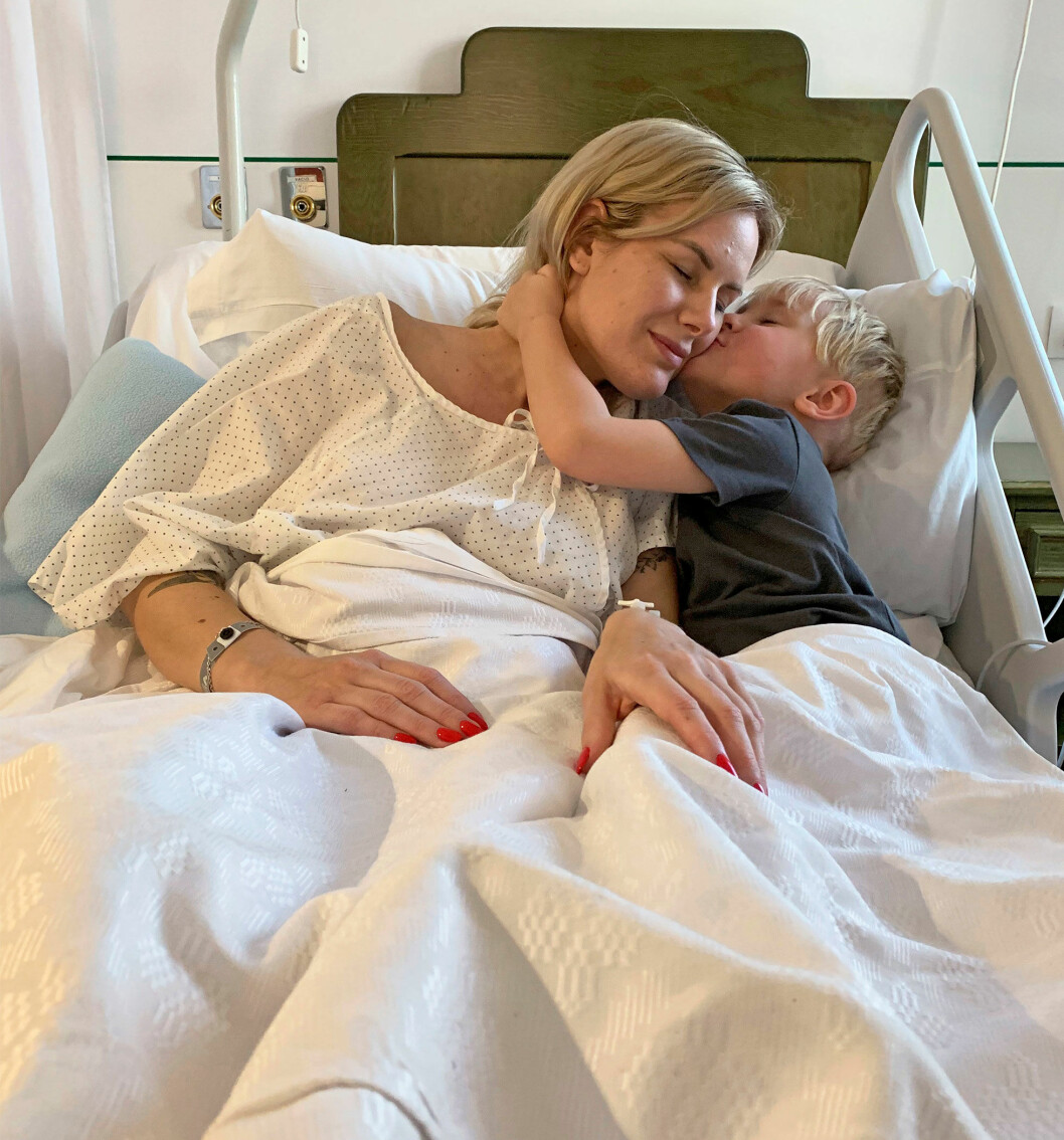Sonen Cornelis kramar om mamma i sjukhussängen. När Elin drastiskt blev sämre trodde läkarna först inte att hon skulle överleva. Sedan blev det amputationer i två steg. Elin ligger i en sjukhussäng och får en puss av sin lille son.