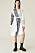 Modell i skjortklänning som är blockmönstrad i vitt, randigt och zebramönstrat. Skjortklänning från Ganni.