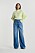 Modell med neongrön stickad tröja och långa blå jeans i lätt oversizad, rak modell. Tröja och jeans från Gina tricot.