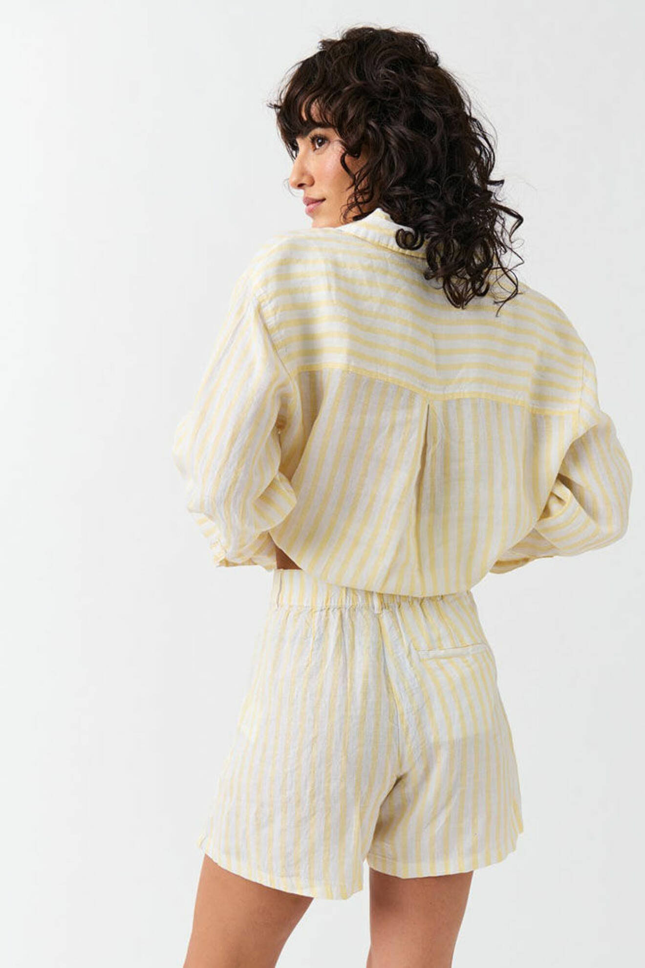 Vita och gula randiga linneshorts med bakficka och veck fram från Gina tricot