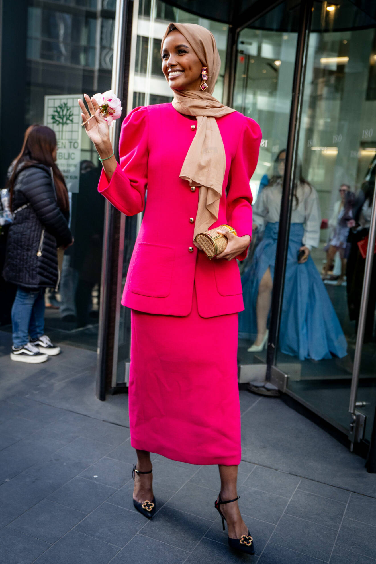 Halima Aden i en ceriserosa dräkt med kjol och jacka till Carolina Herreras AW24-visning på New Yorks modevecka i februari 2024