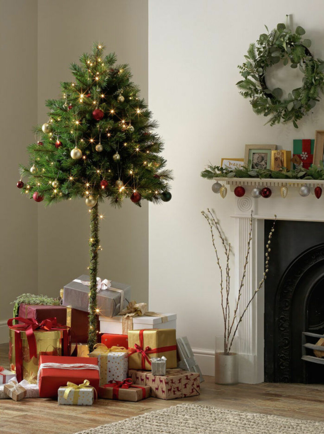 Den halva julgranen är perfekt för dig med husdjur eller busiga barn. Foto: Argos Halv julgran med många julklappar under