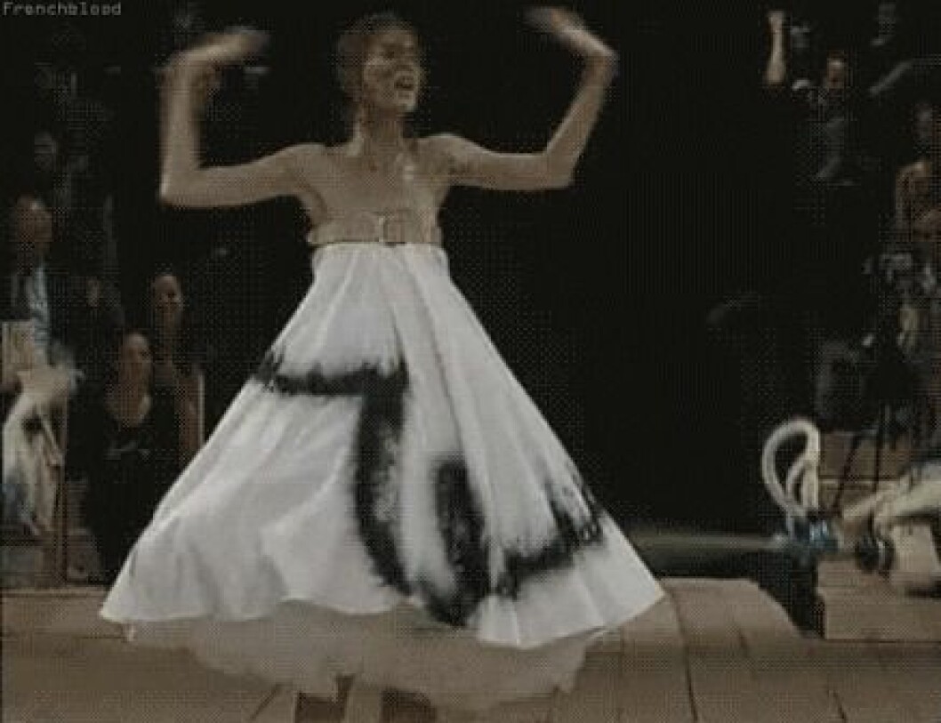 Klänningen Shalom Harlow bar blev snabbt ikonisk. En modell blir nersprutad av robotar på catwalken. Visningen av McQueen ägde rum 1999.