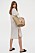 Skjortklänning i lång modell i vit och beigerandigt. Skjortklänningen är plåtad på en modell och stylad med stråväska och platta sandaler. Outfit från H&amp;M.