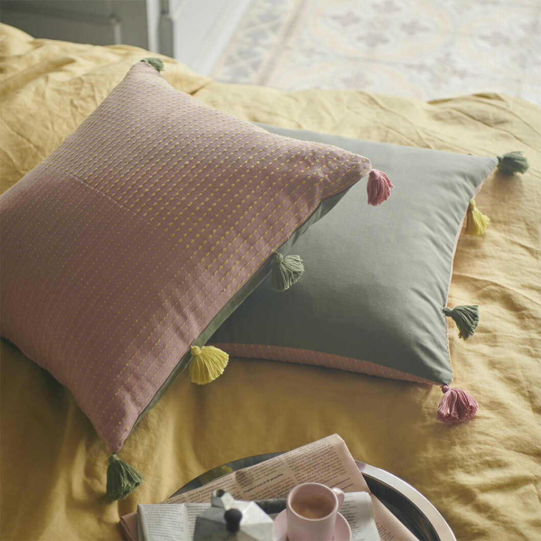Kuddar i rosa, grönt och gult med tofsar från Ikea våren 2020