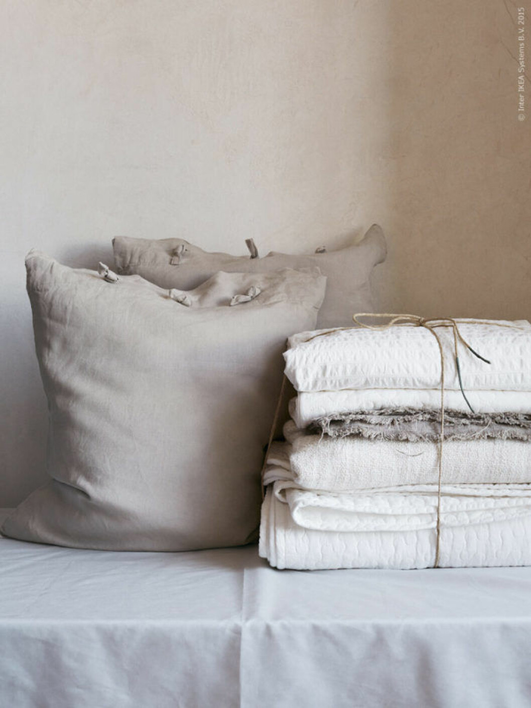 Bild kommer från <a href="http://livethemma.ikea.se/andas-in-varen/" target="_blank">Livet Hemma IKEA</a>. Stylist: Camilla Krishnaswamy Fotograf: Idha Lindhag Dekorativa band på LINBLOMMA örngott. ALINA överkast och kuddfodral, vit, 100 % bomull, 449 kr, AINA metervara grå, 100 % linne, 69 kr/m.
