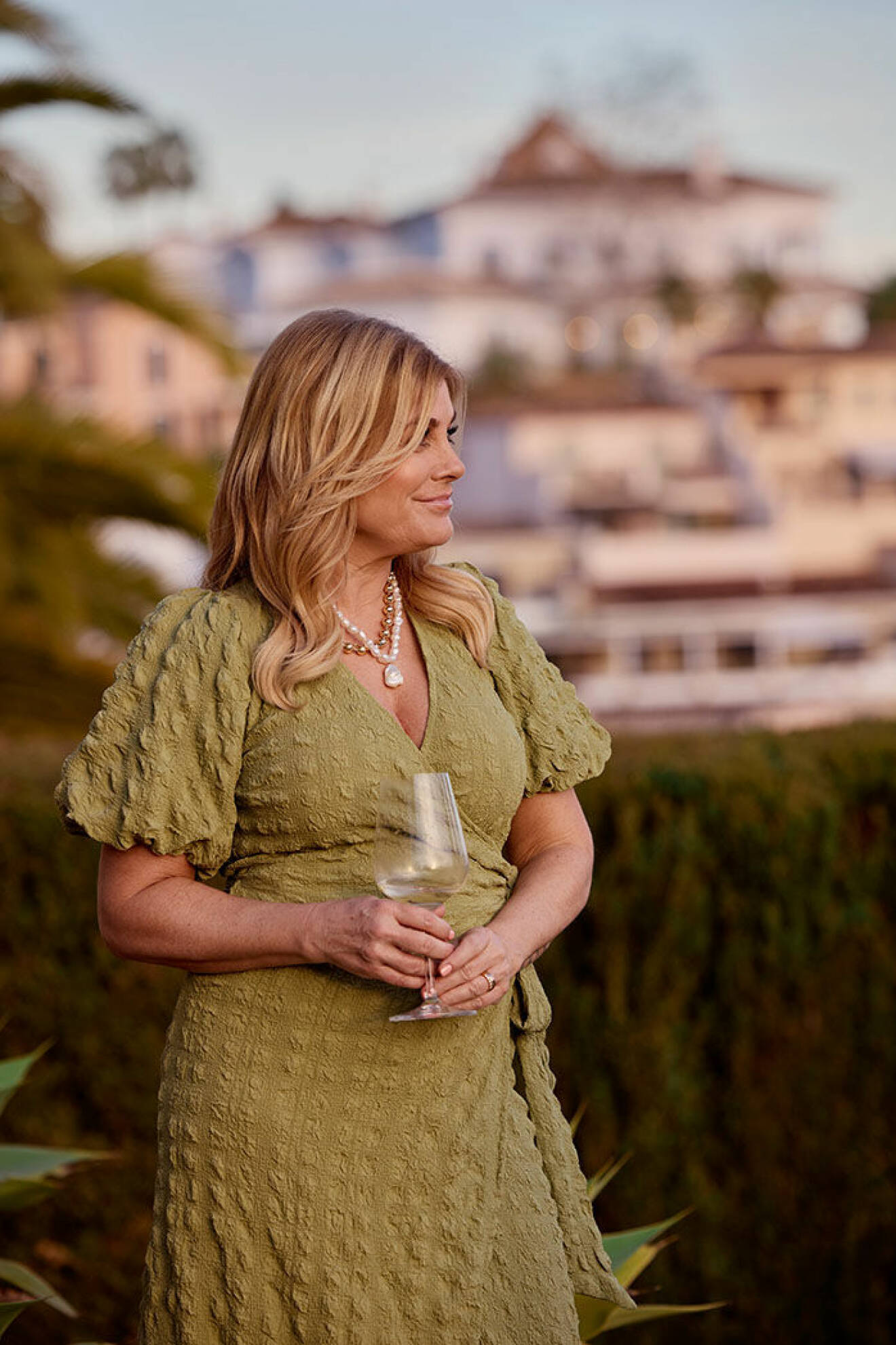 Pernilla Wahlgren i en grön omlottklänning från Ellos i huset i Marbella
