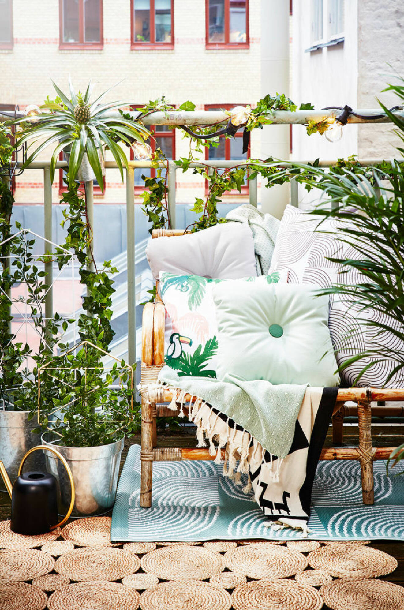 Summer balcony with plants and pillows.