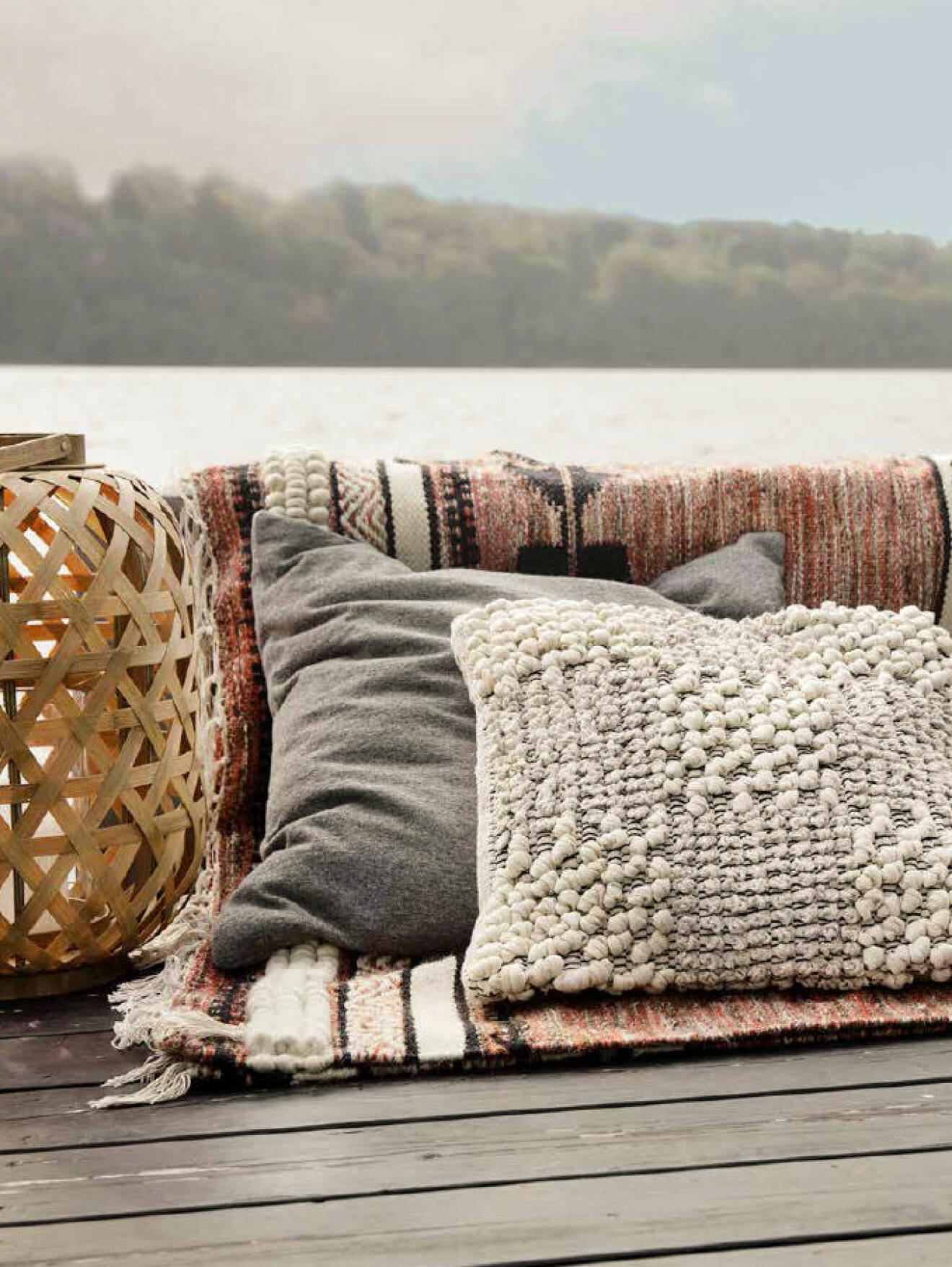 Pillows and rug placed outdoor in the summer.