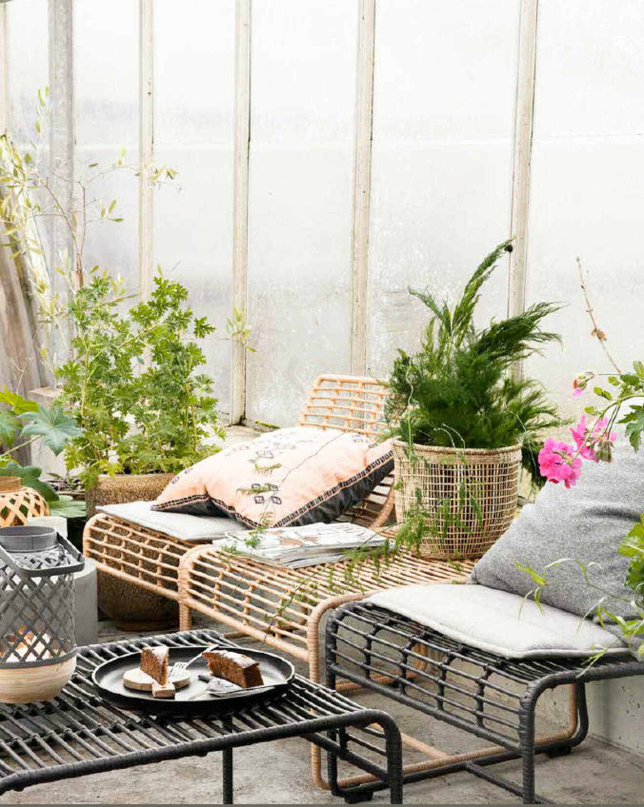 Rattan chairs at the balcony with pillows and plants. Outdoor furniture from House doctor.