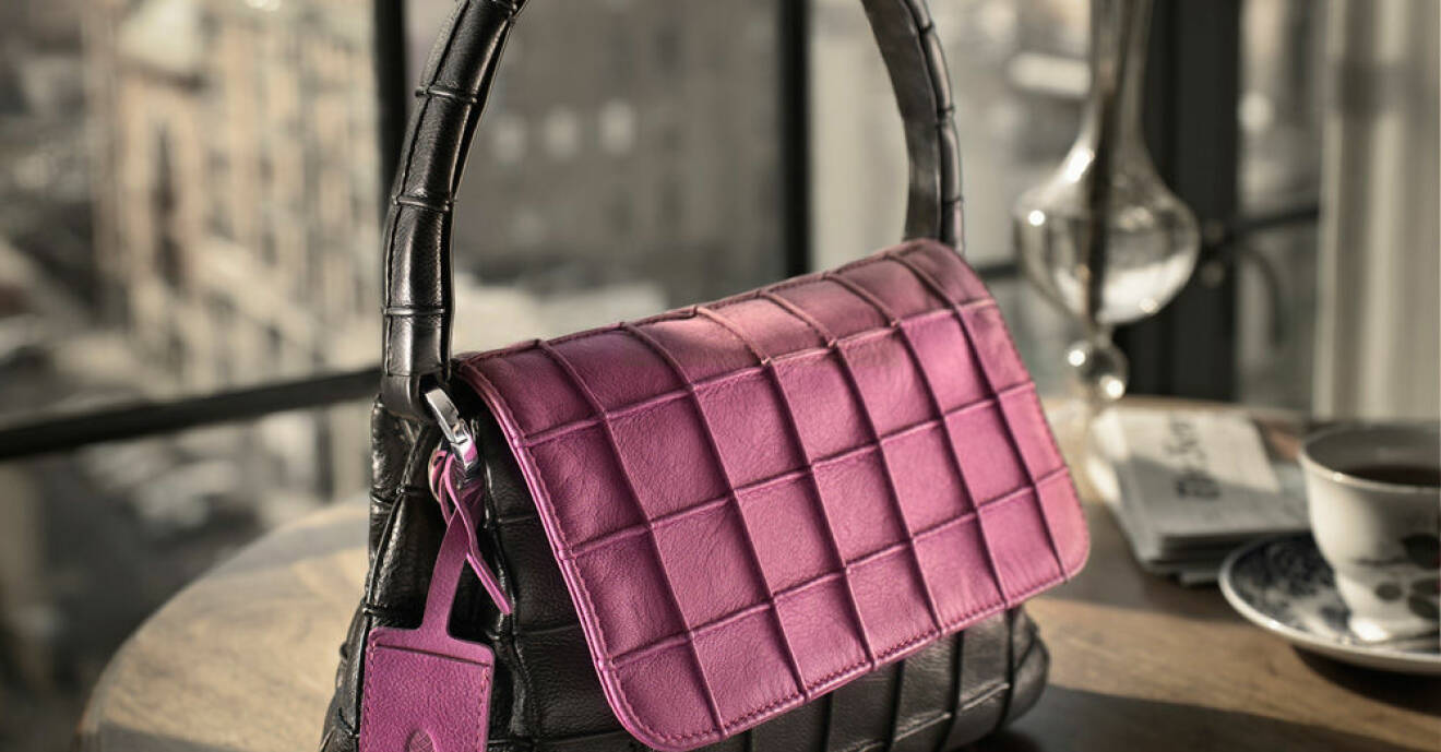 svarta handväska med magentafärgat läder.