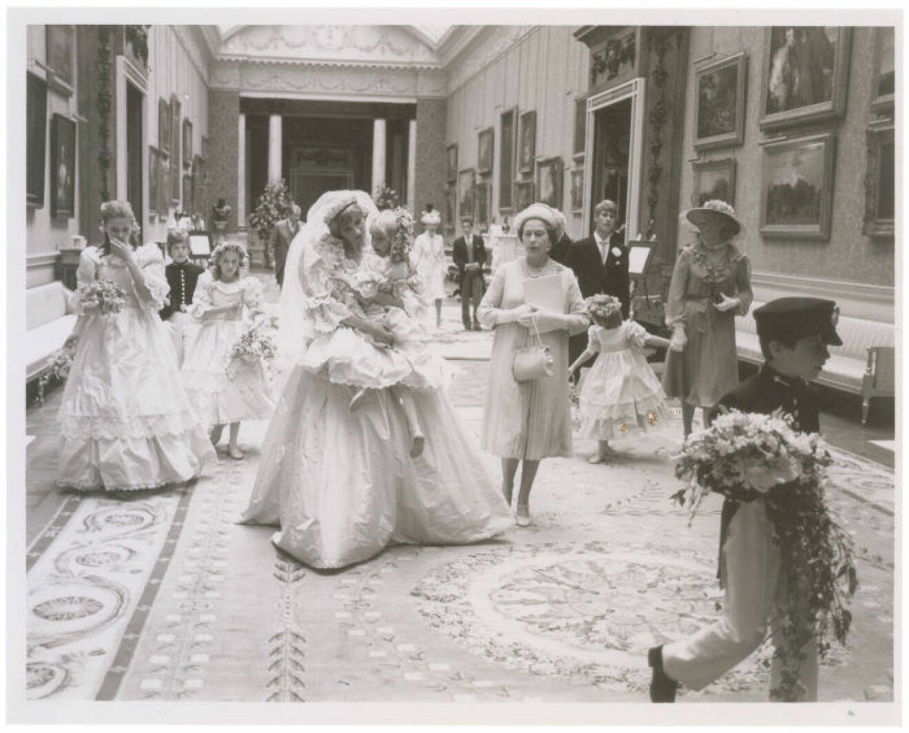 A collection of 12 unpublished behind the scenes photographs from the wedding of Princess Diana and Prince Charles are set to sell for *** when they go under the hammer. The pictures were taken at their reception at Buckingham Palace on July 29 1981 after their wedding ceremony at St. Paul's Cathedral. They originate from the collection of a an assistant to photographer Patrick Lichfield and include seven black and white pictures and five color, as well as the assistant's access pass to the palace. Six of the larger photos depict Princess Diana wearing her gorgeous wedding dress with members of her family and wedding party, including Queen Elizabeth, Prince Charles, Princess Ann, Princess Margaret, and Prince Andrew. Three show Princess Diana holding the five-year-old Clementine Hambro, her youngest bridesmaid; one shows her setting Clementine down; and another shows her smiling as Prince Andrew leans over to talk to Clementine. Queen Elizabeth is clearly visible walking alongside Princess Diana in four of the images, and the Queen Mother is seen in two. Prince Charles is also in two of these photographs. The last of the photos is the most striking of all, depicting Princess Diana and Prince Charles from behind on the famous balcony overlooking the massive crowds gathered on the Mall in front of Buckingham Palace. The lot will be sold by RR Auction in Cambridge, MA, on September 24 2015. Ref: SPL1098968 100815 Picture by: RR Auction / Splash News Splash News and Pictures Los Angeles: 310-821-2666 New York: 212-619-2666 London: 870-934-2666 photodesk@splashnews.com 