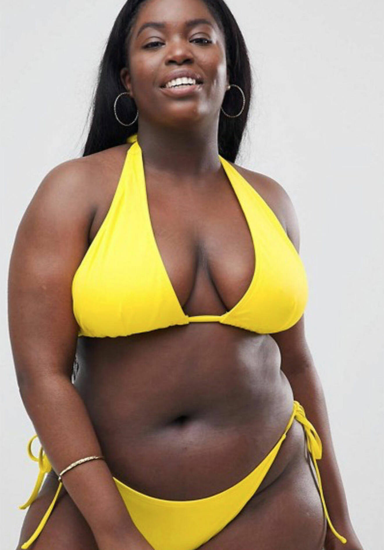 Modellen Vivian Eyo-Ephraim i gul bikini från ASOS Curve. 