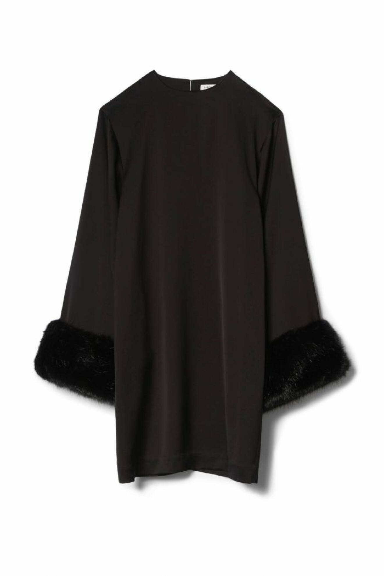 A-linjeformad svart klänning med fuskpäls vid ärmsluten. Från Totême