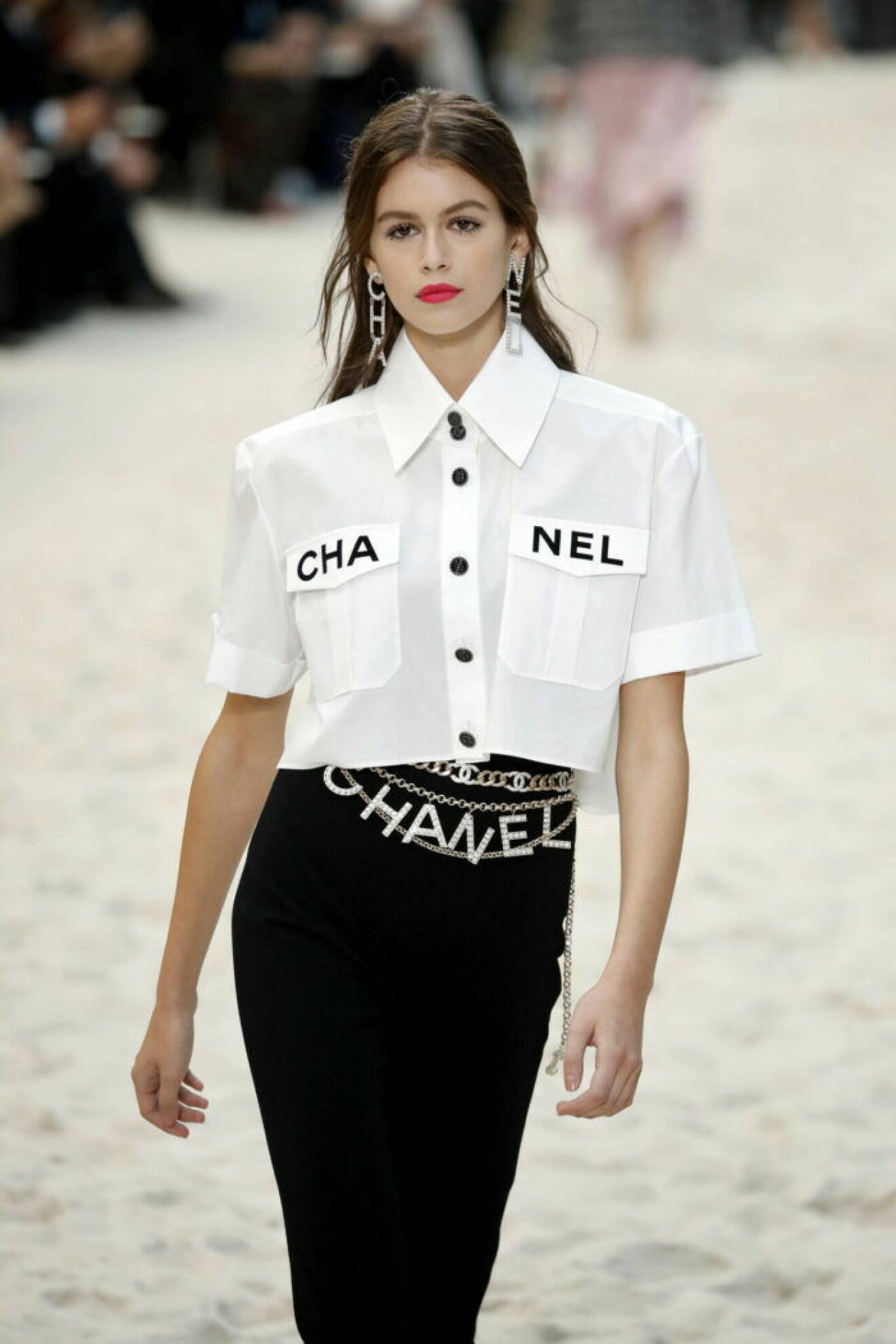 Karl Lagerfelds visning för Chanel 2019, vit skjorta med chaneltryck och ett glittrigt chanelbälte.