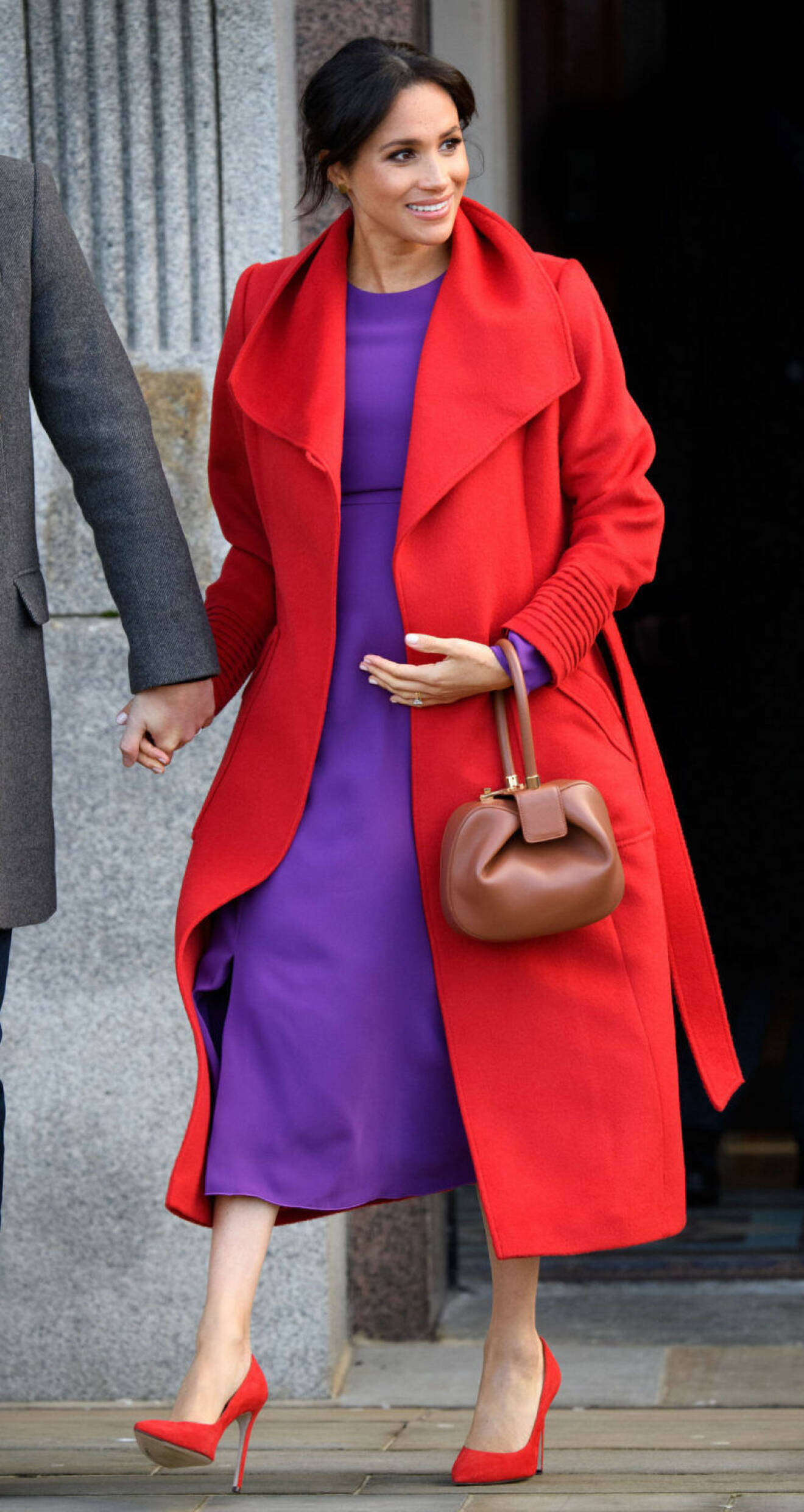 Meghan Markle i lila klänning och röd kappa
