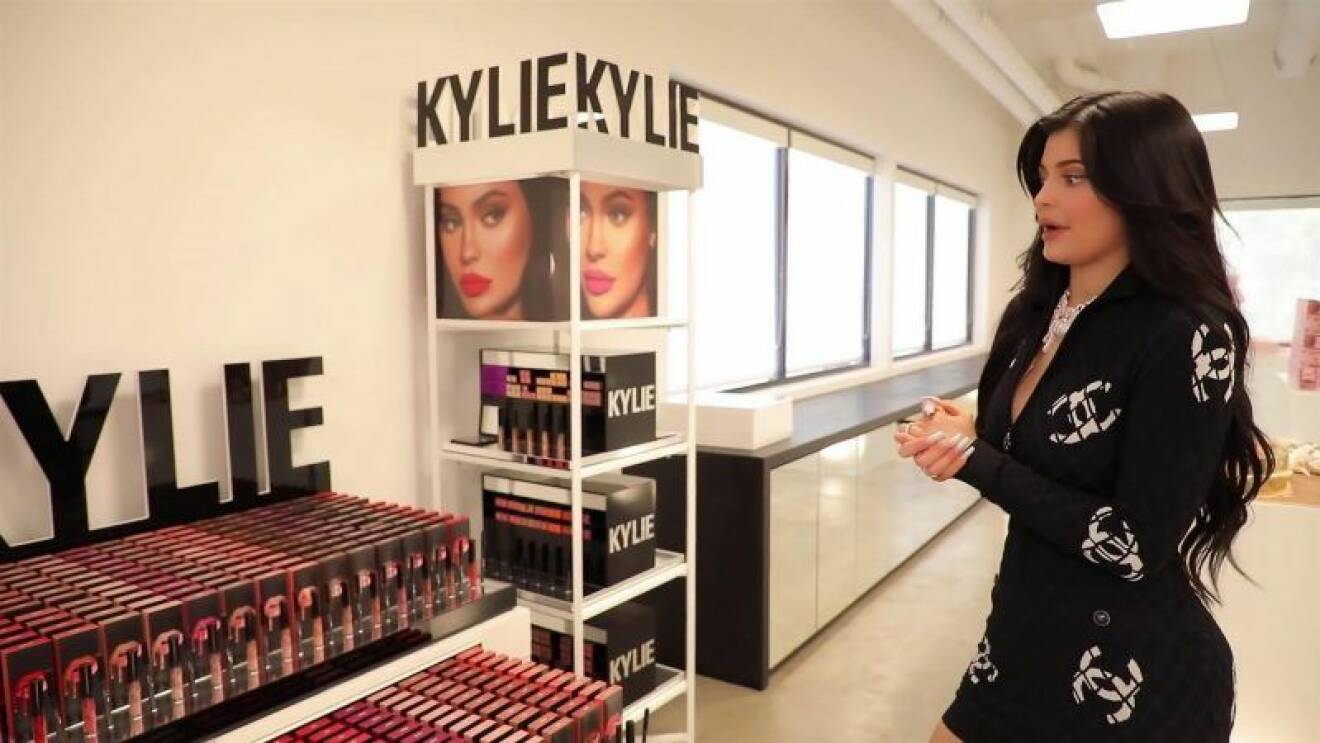 Kylie Jenner står framför smink av märket Kylie Cosmetics