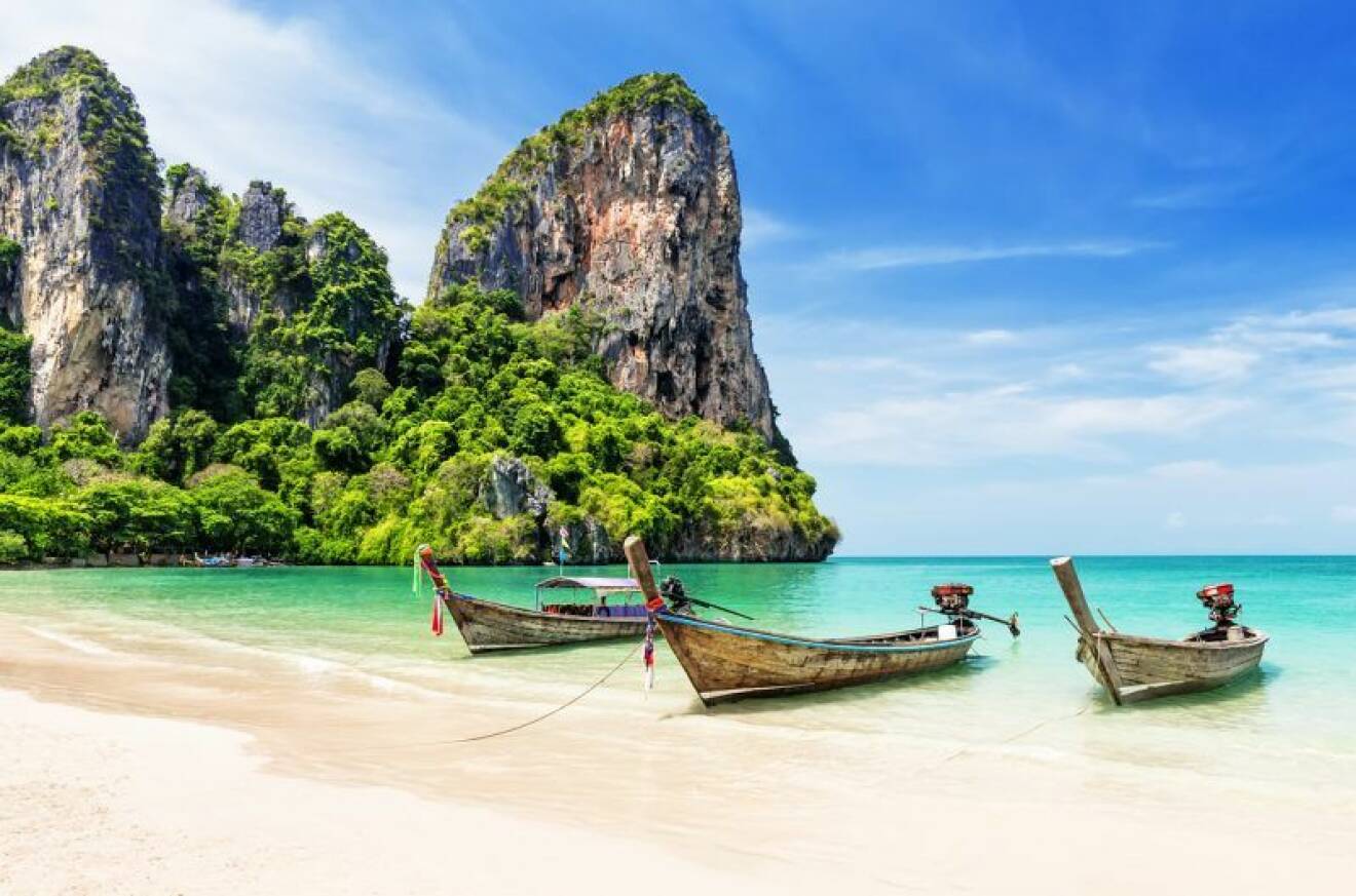 Thailändsk strand med longtailbåtar