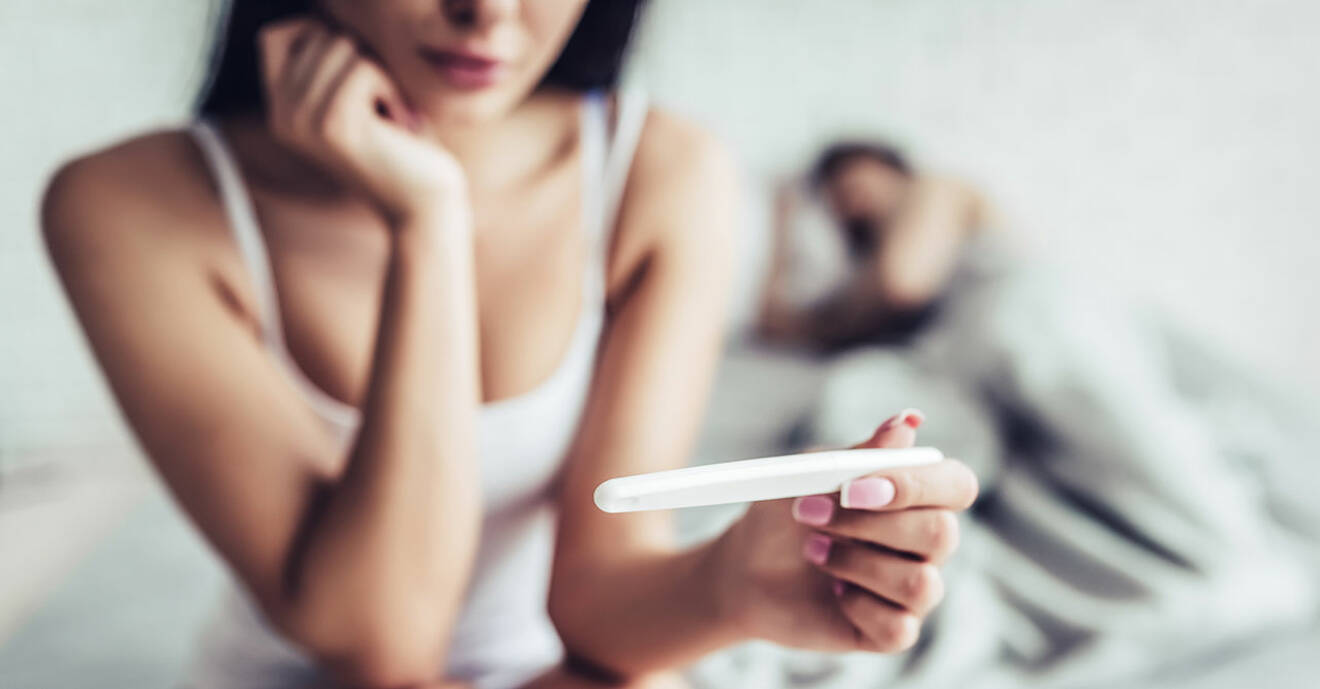 Par i säng med graviditetstest. Sömnen är viktig för både mannens och kvinnans fertilitet.