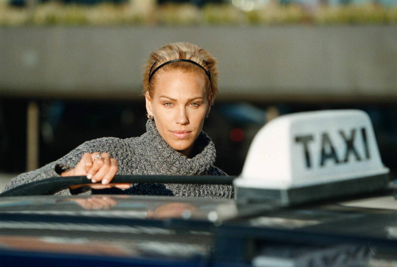 Emma Sjöberg med hårband vid en taxi.